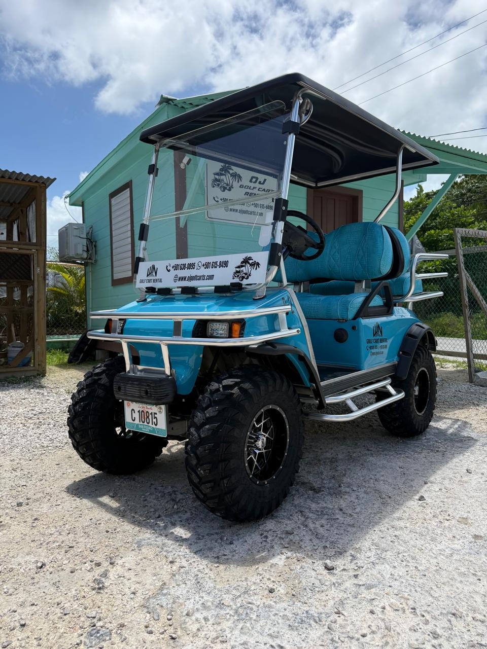 OJ Golf Cart Rentals fleet — turquoise 4-person golf cart in San Pedro Belize