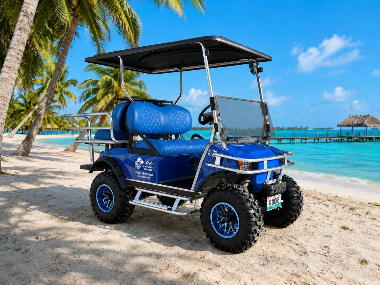 OJ Golf Cart Rentals blue 4-passenger golf cart on the beach with palm trees and pier in San Pedro, Ambergris Caye, Belize
